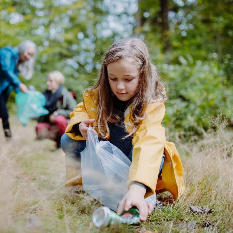 Little girl helping pick up trash in the community.